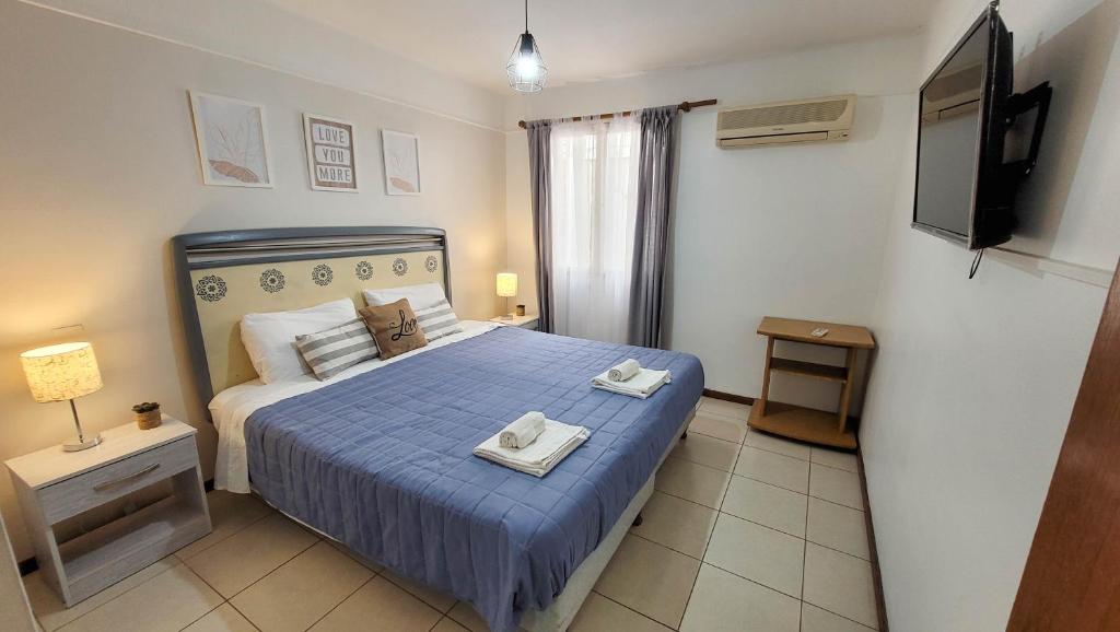 门多萨La Quinta departamento的一间卧室配有蓝色的床和2条毛巾