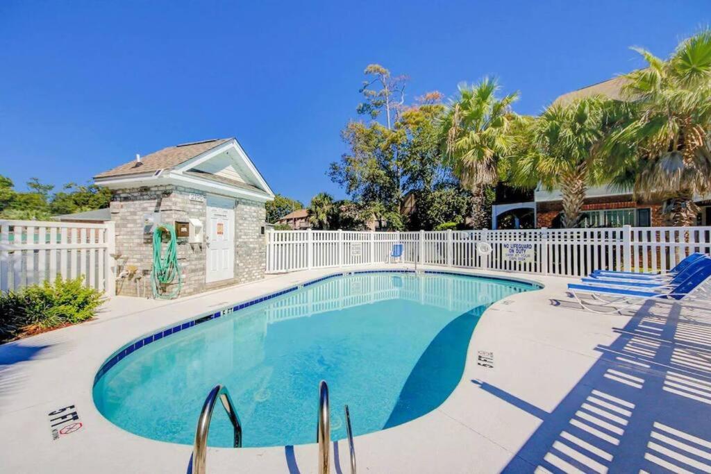 默特尔比奇Spacious House with Pool near the Beach 2165的一个带椅子和围栏的游泳池