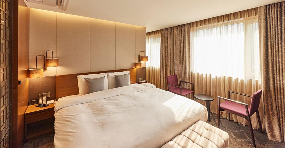 首尔Hotel Uri&的酒店客房带一张床、一张桌子和椅子