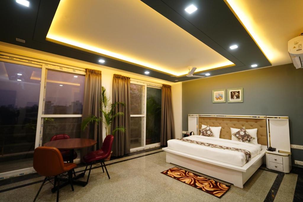 古尔冈Posh Garden Inn Artemis Hospital Road Gurgaon的卧室配有一张床和一张桌子及椅子
