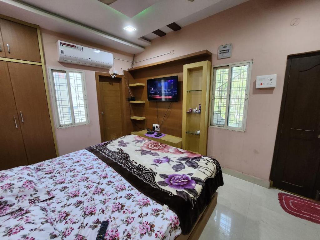 海得拉巴SCK Home Stay的一间卧室配有一张床和一台电视。