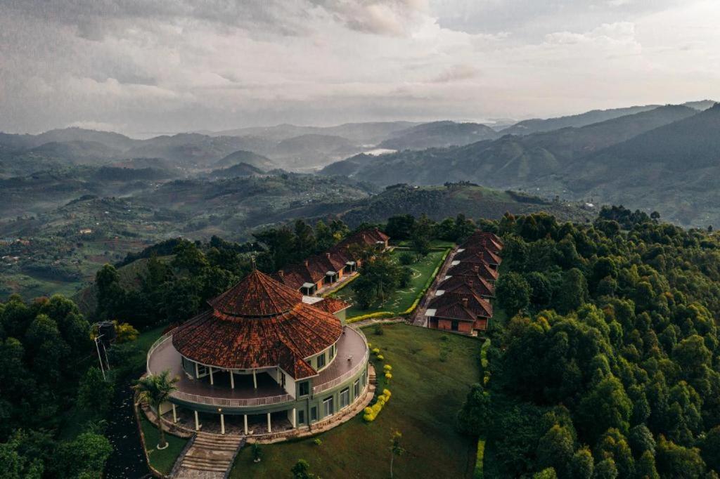 RwumbaNyungwe Hill View Hotel的享有建筑的空中景观,以群山为背景