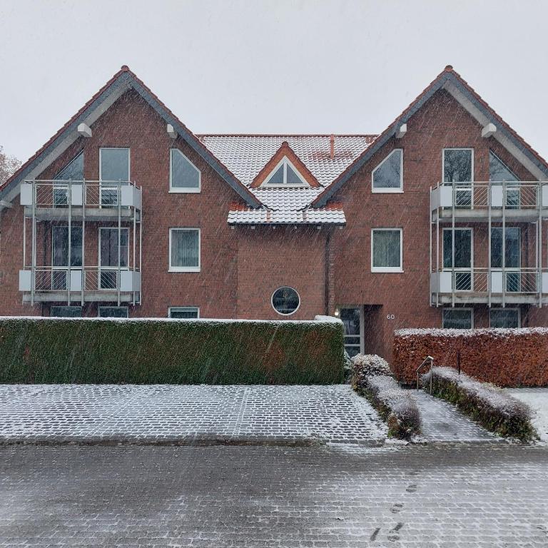 巴特德里堡Gästehaus Therme-Blick的一座大砖房,地面上积雪