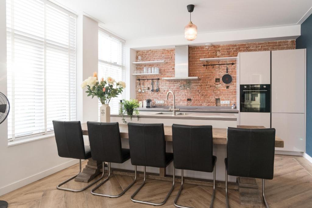 哈莱姆Kampervest Apartment Haarlem的厨房配有桌子和黑色椅子