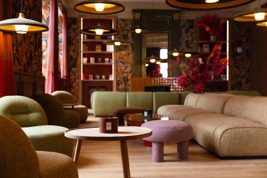 阿让Serra Boutique Hôtel的客厅配有沙发和桌椅