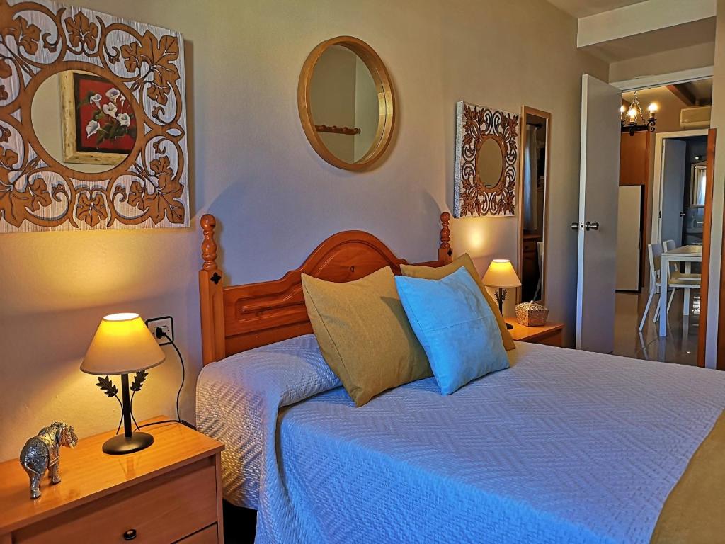 卡索拉Alojamiento Martinez 1的一间卧室配有一张带蓝色床单和镜子的床