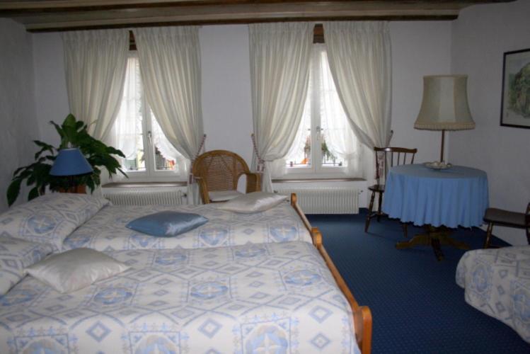 特湾祖姆阿尔滕施魏策尔酒店的卧室配有床、桌子和窗户。