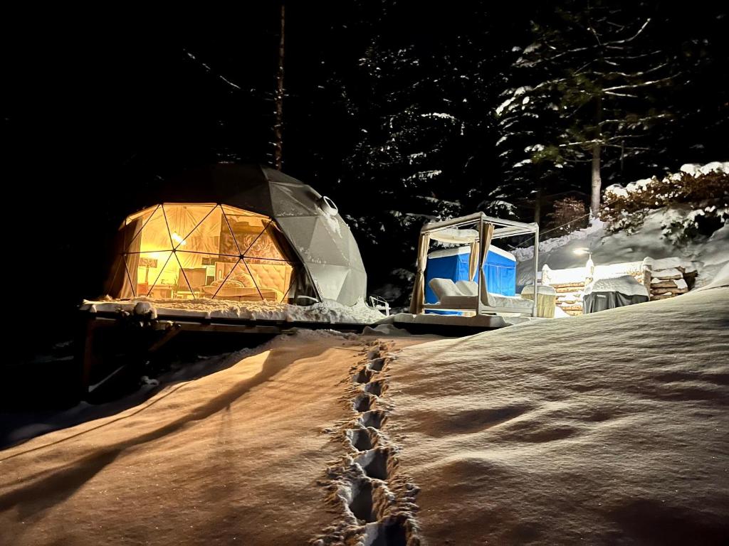 什平德莱鲁夫姆林Glamping Špindl的夜间雪地里两个圆顶帐篷