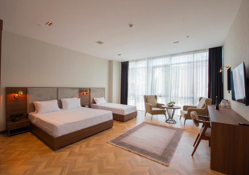 图兹拉Moncher Hotel的配有一张床和一张书桌的酒店客房
