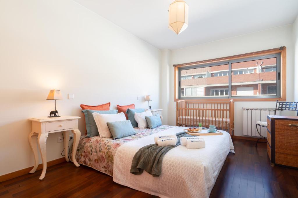 吉马良斯Homely Large Flat - Balcony的一间卧室设有一张大床和一个窗户。
