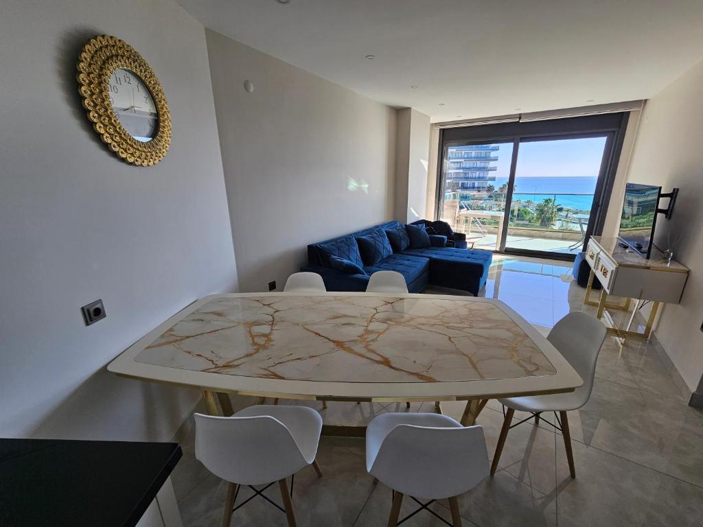 阿拉尼亚Konak Tower Seaside mahmutlar的客厅配有桌子和蓝色沙发