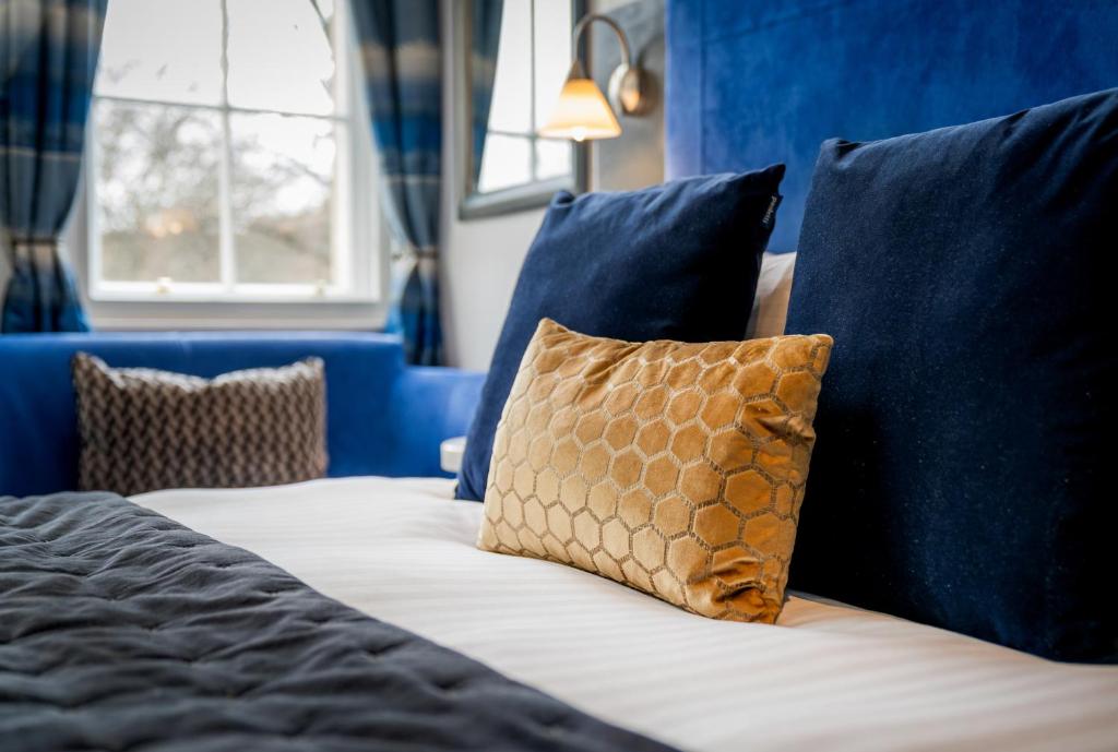 布里斯托布里斯托尔伯克利广场酒店的床上配有蓝色枕头和棕色枕头