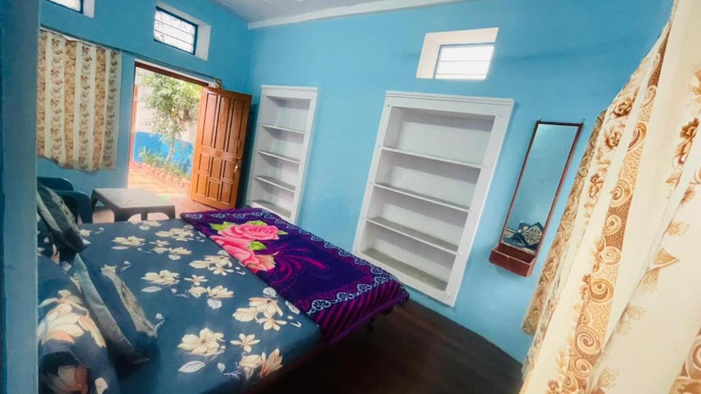 布什格尔GUEST HOUSE INN的蓝色的卧室,床上有鲜花