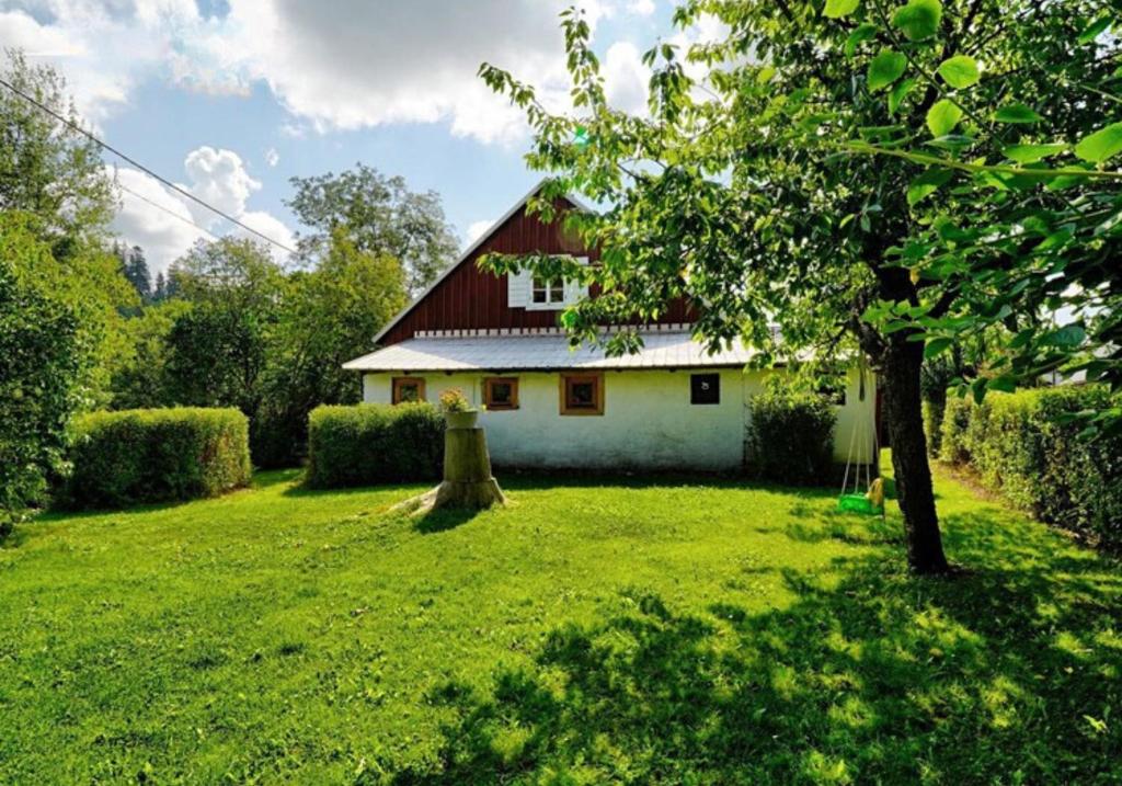 小莫拉夫卡Chaloupka Malá Morávka的院子里有红色屋顶的白色房子