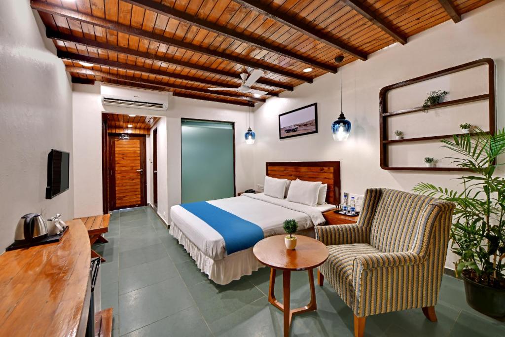 博尔本德尔The Fern Leo Beach Resort , Madhavpur的酒店客房带一张床、一张桌子和椅子