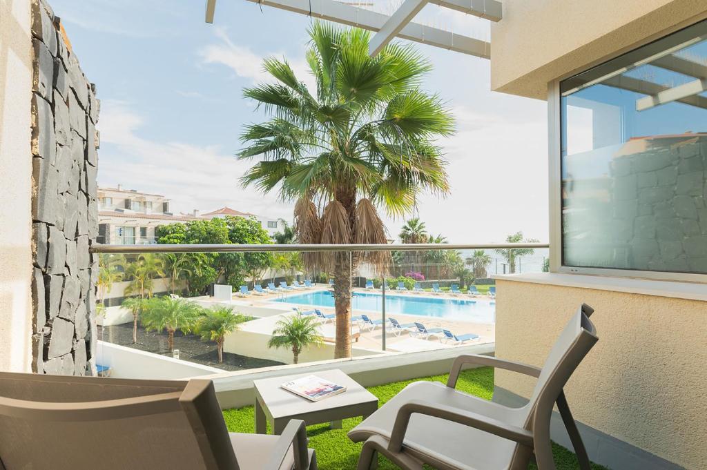 圣米格尔德阿沃纳Relax Golf cerca de la playa的阳台享有棕榈树和游泳池的景致。