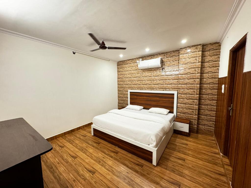 法里达巴德Hotel Walk Inn的一间卧室设有一张床和砖墙