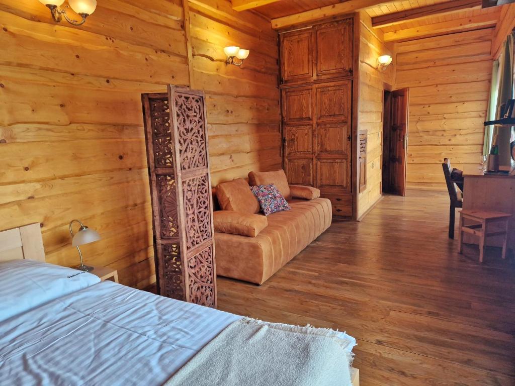 MnichoviceSport-hotel Šibeniční vrch的小木屋内的一个房间,配有一张床和一张沙发