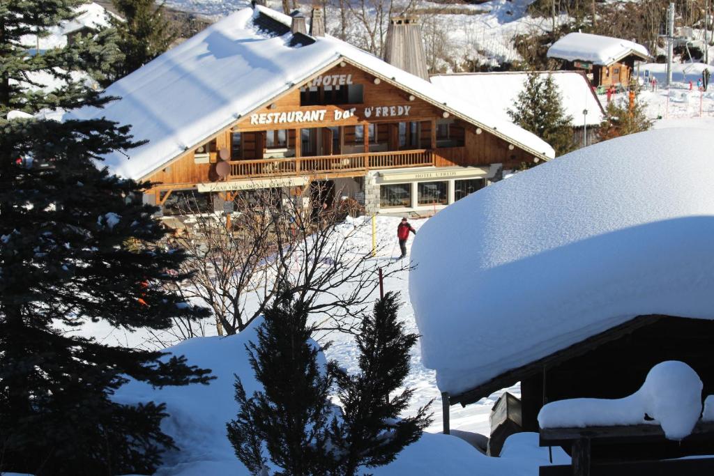拉克吕萨弗莱迪餐厅酒店的雪覆盖的小木屋,有雪覆盖的屋顶