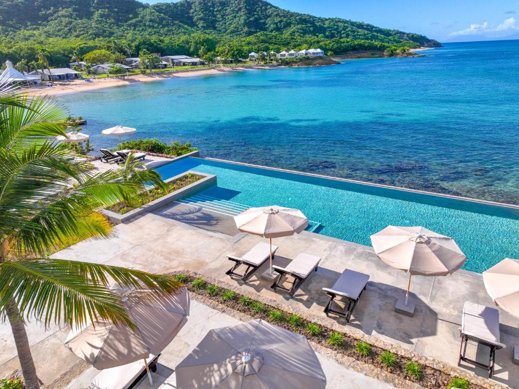 Five Islands VillageHawksbill Resort Antigua - All Inclusive的享有带遮阳伞的泳池和大海的空中景致