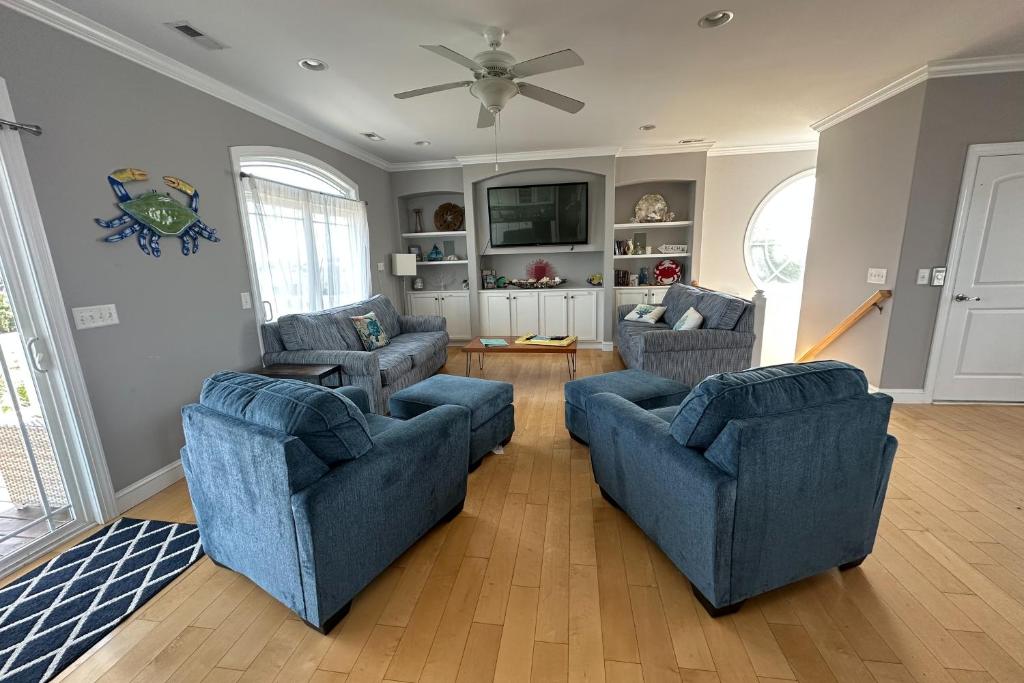 霍尔顿海滩Bird's Nest的客厅配有2把蓝色椅子和电视