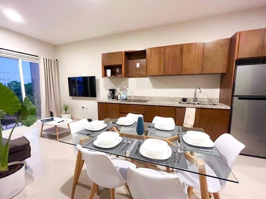 马萨特兰Condominio en Lomas de Mazatlán的厨房以及带桌椅的用餐室。