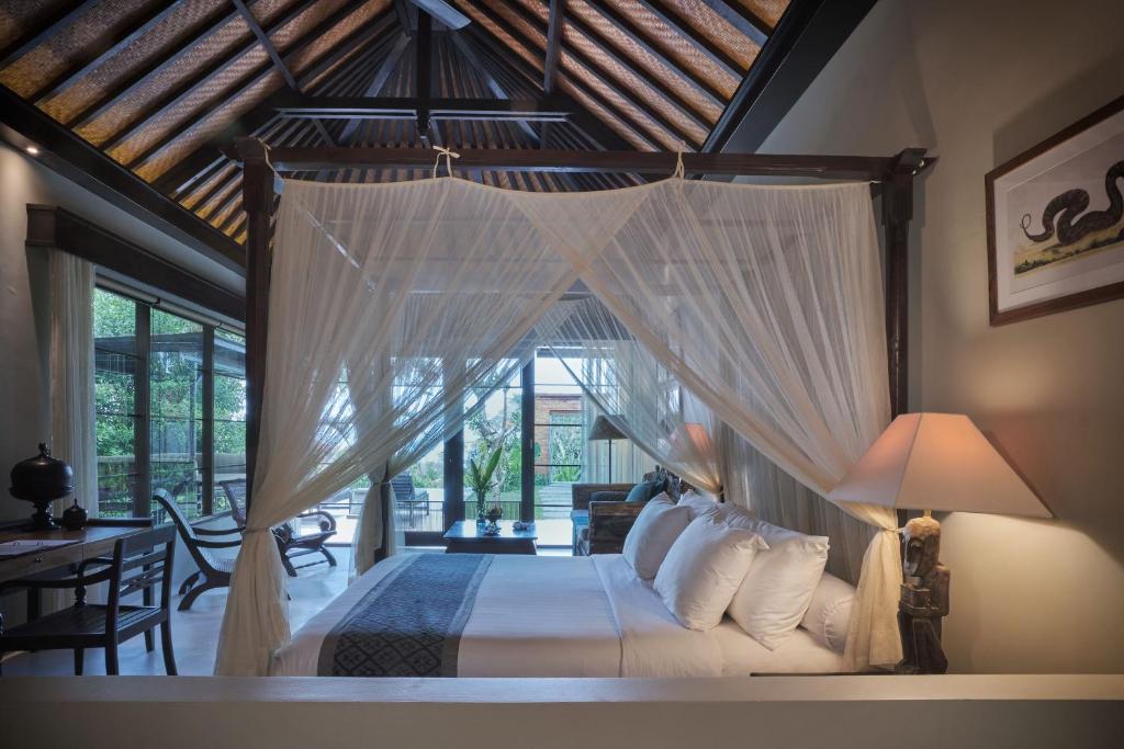 罗威那达迈酒店的一间卧室配有一张带天蓬的床