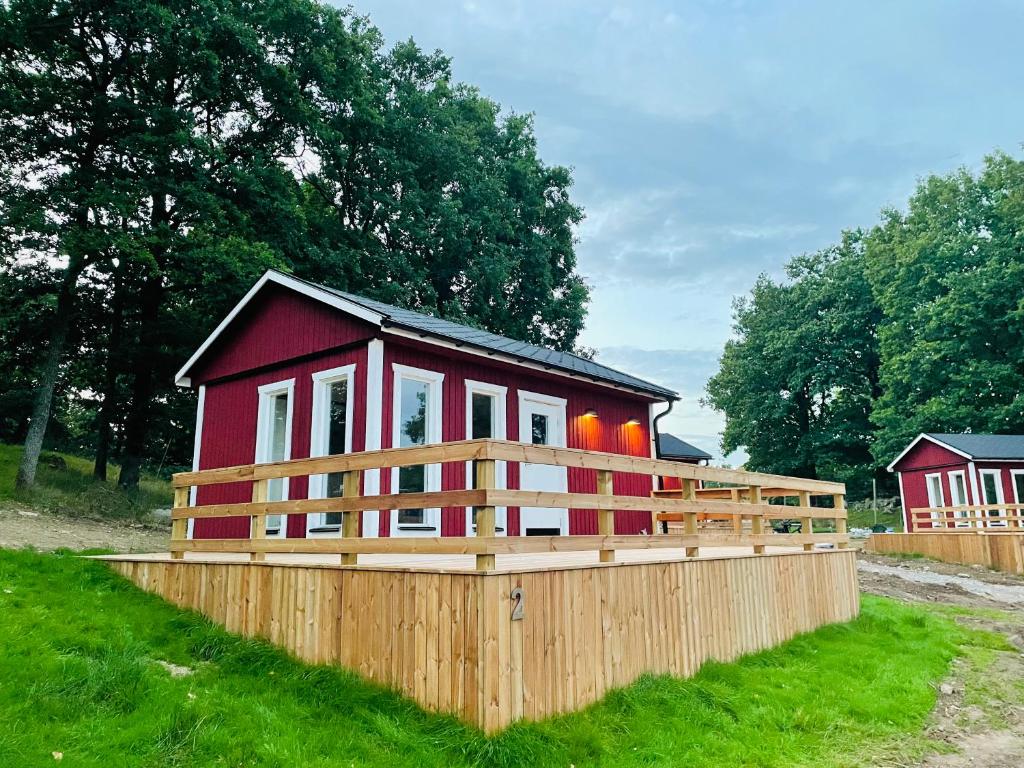 拉霍尔姆Stuga - Ulvereds Hjorthägn的一座红色的小房子,四周有木栅栏
