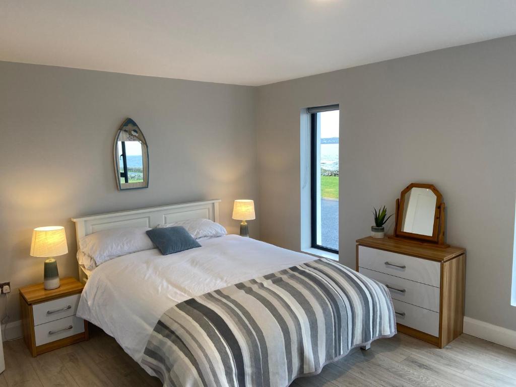 利斯坎诺Spectacular ocean views & minutes to Cliffs- Clahane Shore Lodge的一间卧室配有一张床、镜子和窗户
