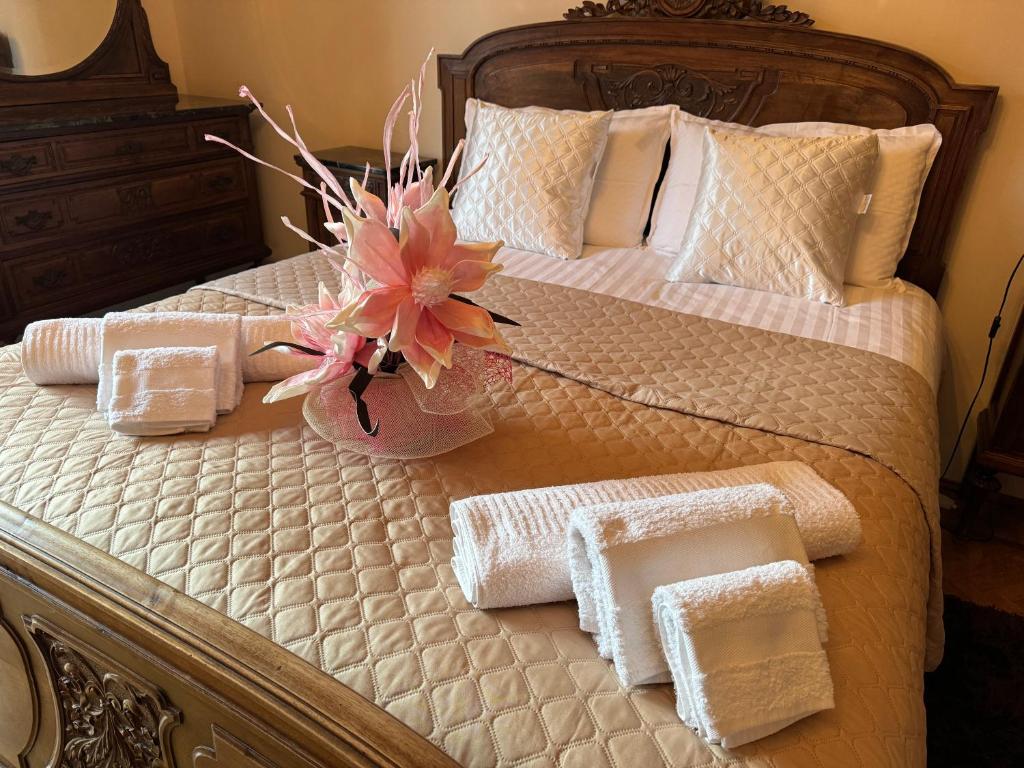 维纳利亚瑞勒Ca' Mariuccia appartamento in Venaria Reale的一张带毛巾的床和一个花瓶