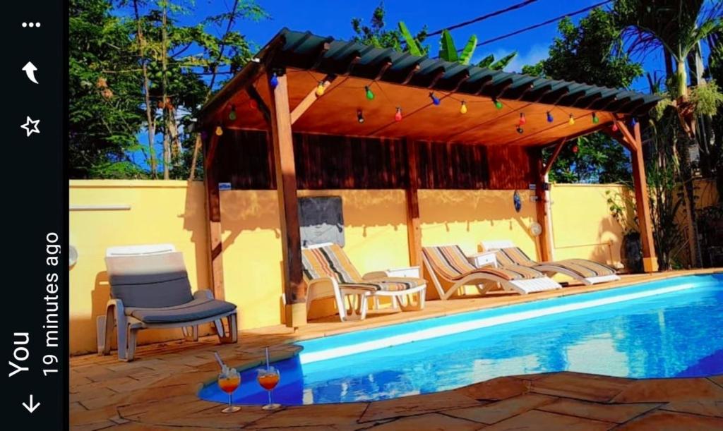 潘托皮芒3 bedrooms villa with shared pool furnished terrace and wifi at Pointe aux Piments的一个带椅子的游泳池和一个凉亭