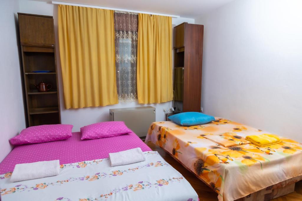 尼什Apartment Bojke的配有黄色窗帘的客房内的两张床