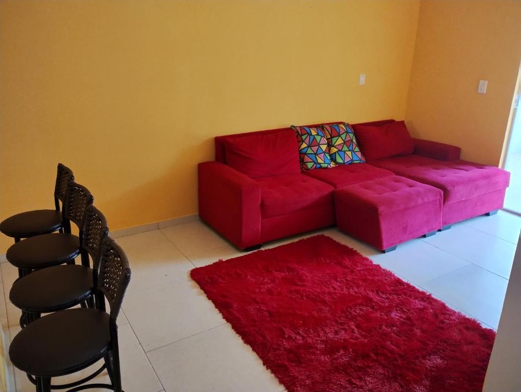曼加拉蒂巴Apartamento Mangaratiba 2 suites的客厅配有红色沙发和红色地毯