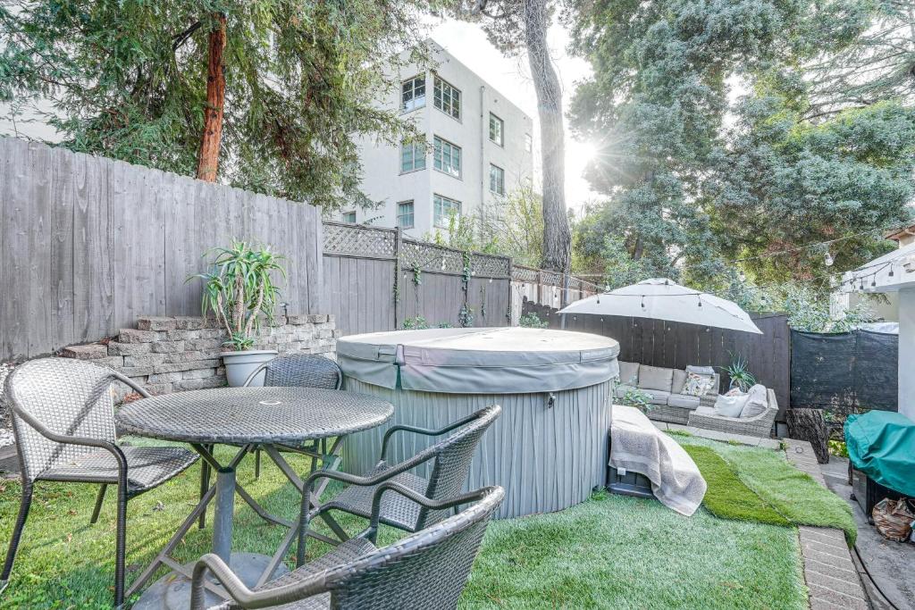 奥克兰Oakland Apartment with Shared Hidden Backyard Oasis!的庭院配有桌椅和遮阳伞。