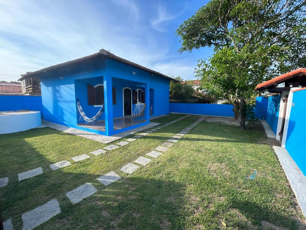 萨夸雷马Casa na esquina da praia com quintal的庭院内带吊床的蓝色房子