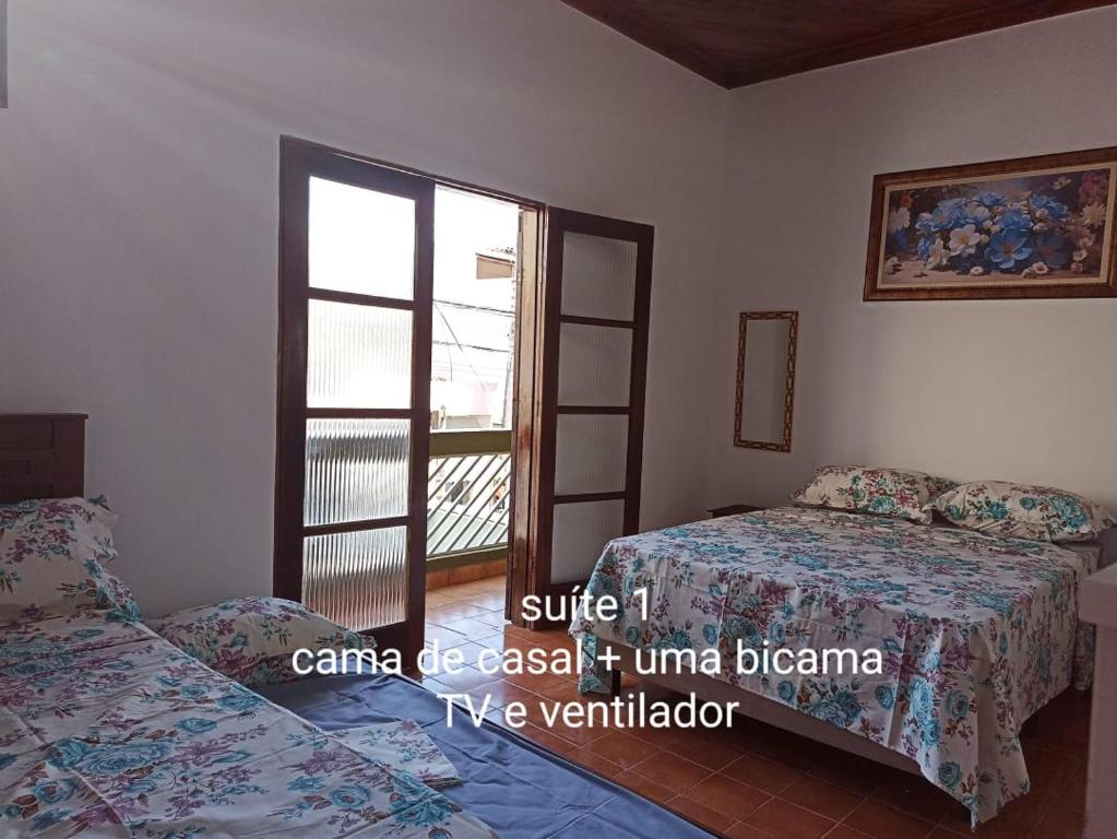 阿帕雷西达Casa para 12 pessoas perto da Basílica e da Feira的一间卧室设有两张床和窗户。
