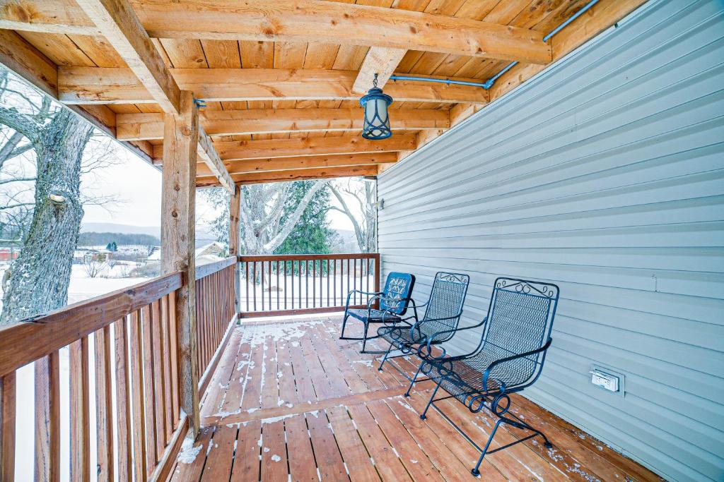 Jones Mills Vacation Rental Near Skiing and Hiking!的门廊上的两把椅子和木屋顶