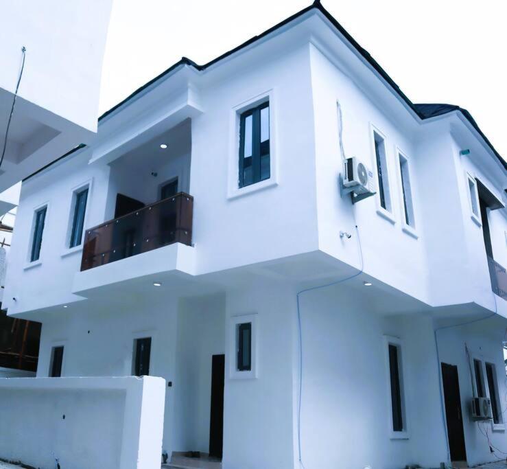 IkuataLuxury Charming 5Bed Duplex With Starlink wifi - Lekki的一座白色的建筑,上面设有一个阳台