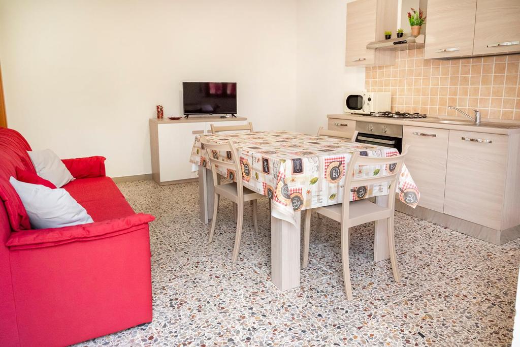 西尼加利亚SE035 - Senigallia, nuovissimo bilocale con ogni comfort的厨房配有桌子和红色沙发