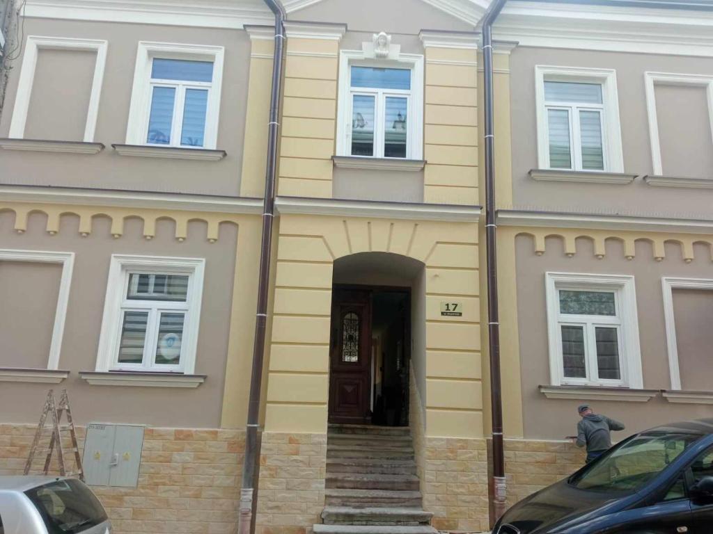 普热梅希尔Rafaelo Władycze 17/4的前面有门和楼梯的黄色房子