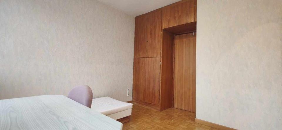 帕坦Cosy Room的一间卧室配有一张床和一个木制橱柜