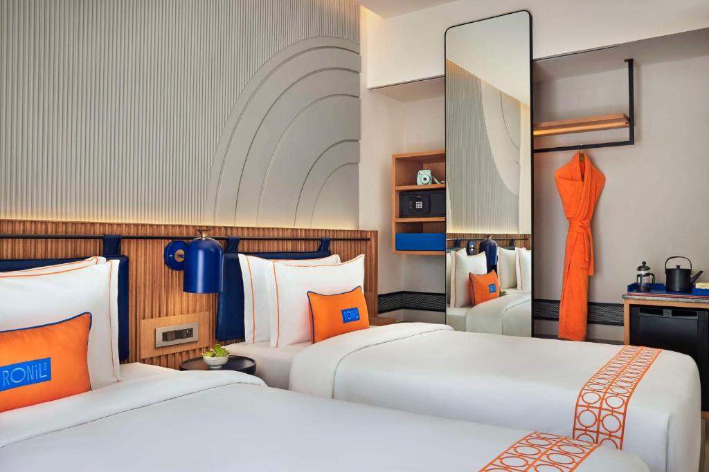 卡兰古特Ronil Goa - a JdV by Hyatt Hotel的橙色和蓝色的客房内的两张床