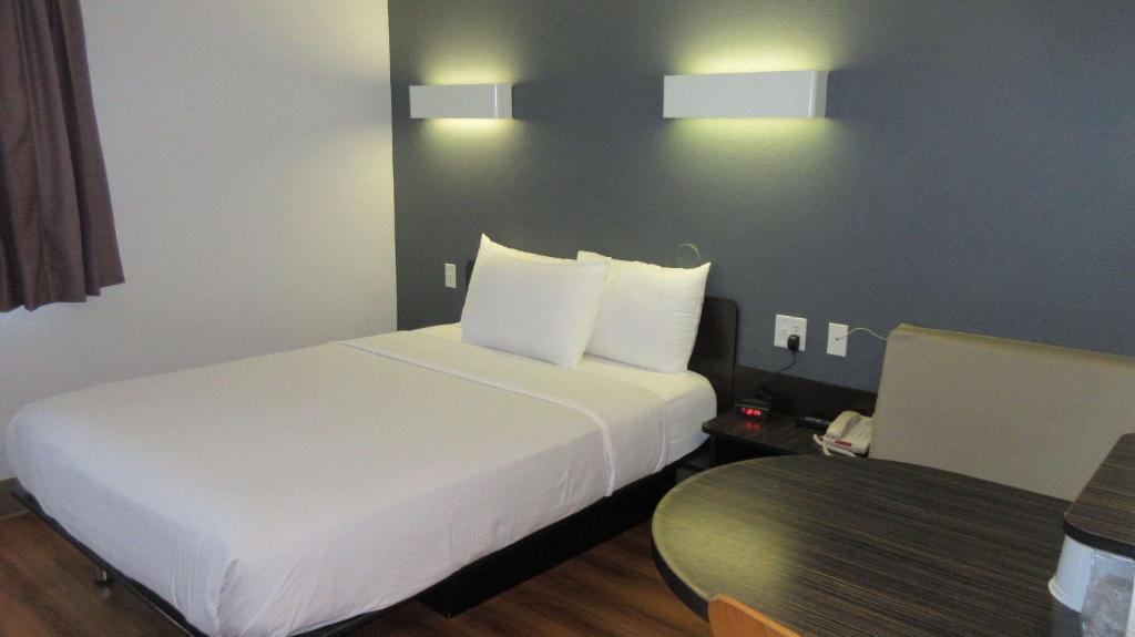 爱达荷福尔斯Econo Lodge的酒店客房配有白色的床和桌子