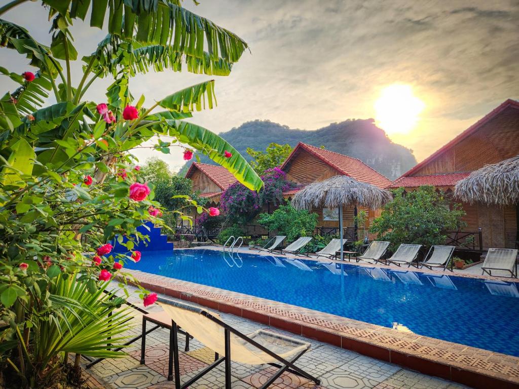 宁平Trang An Quynh Trang Happy Homestay & Garden的一座带椅子和鲜花的度假村游泳池