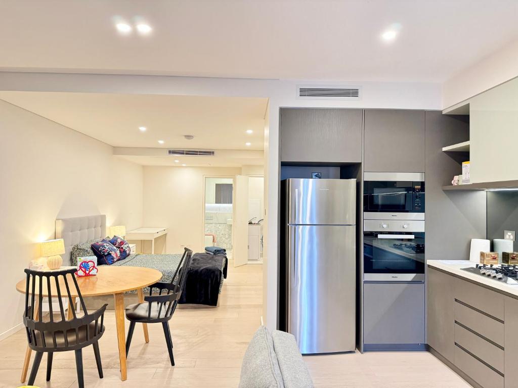悉尼New Town Studio的厨房以及带桌子和冰箱的客厅。