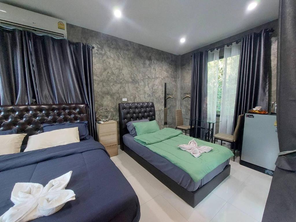 Baan Pak Arom Resort Chanthaburi的一间卧室配有两张床和一张桌子及椅子