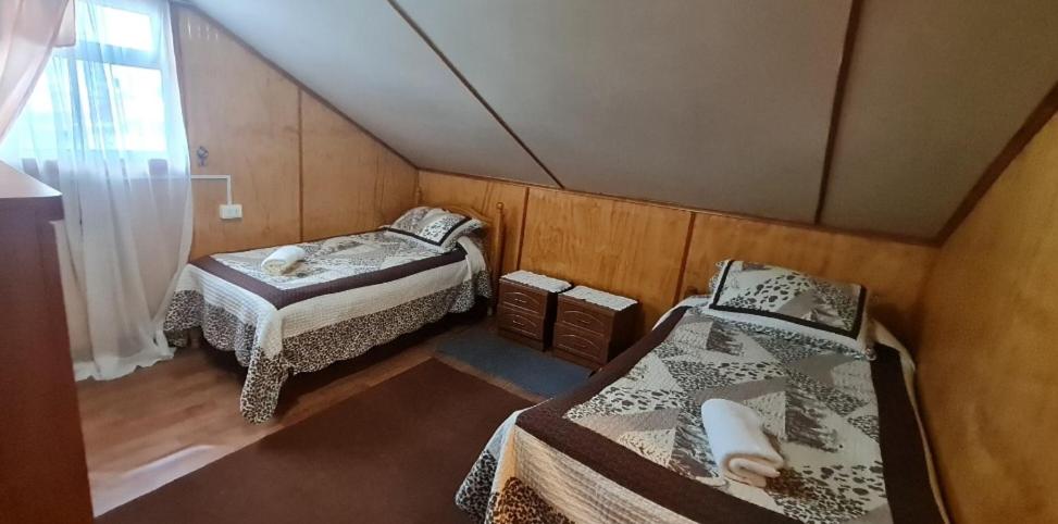 威廉斯港Hostal Beagle的小房间设有两张床和窗户