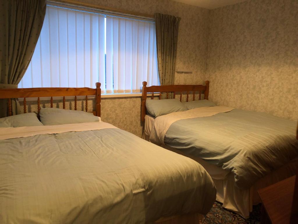 布莱克浦Blackpool Serviced Apartments的带窗户的客房内的两张床