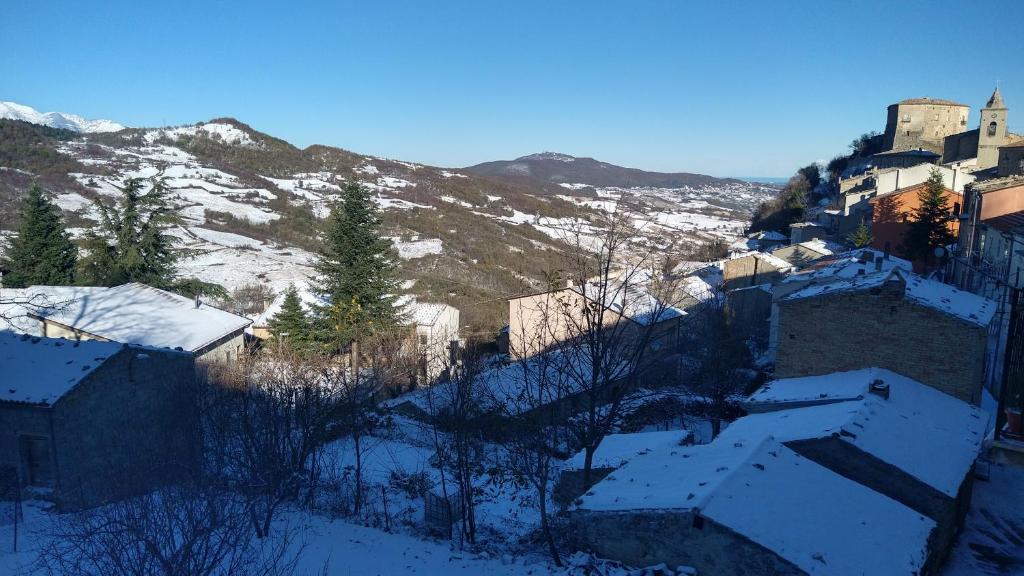 MontazzoliCorso 46的一座有雪盖屋顶的村庄和一座山