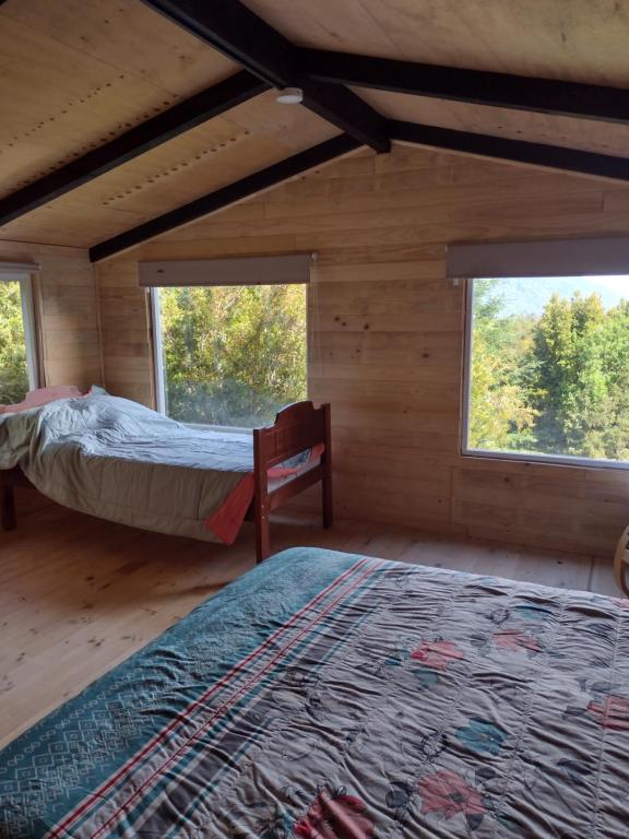蒙特港Casa Aoni的一间设有2张床的卧室,位于带窗户的小屋内